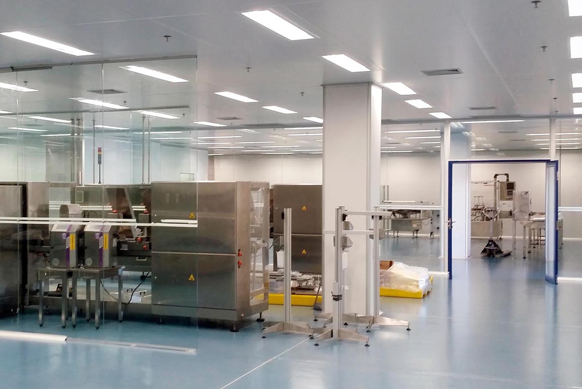 Clean industrial room with stainless steel machinery and equipment on a shiny blue floor.